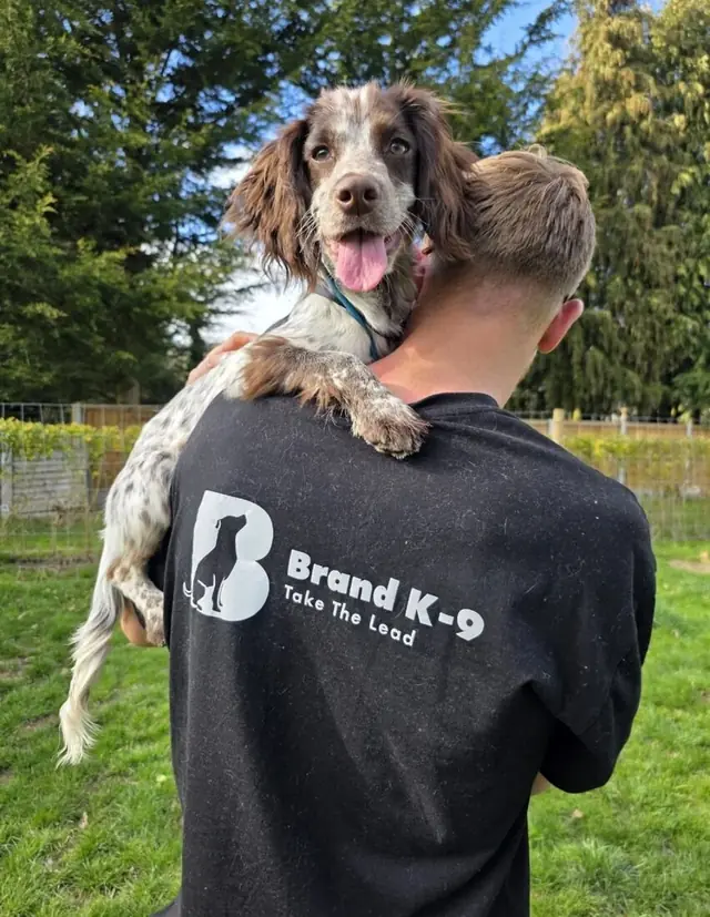 Josh carrying a spaniel puppy